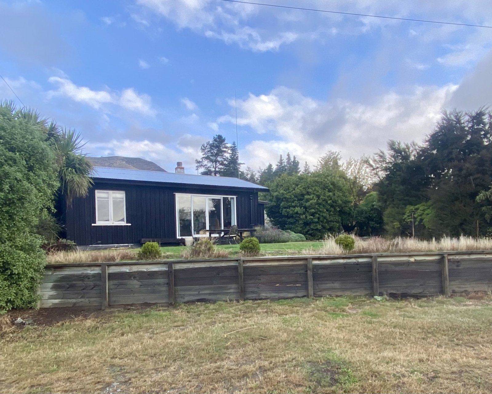 The Black Shack exterior with fence, Lake Hawea