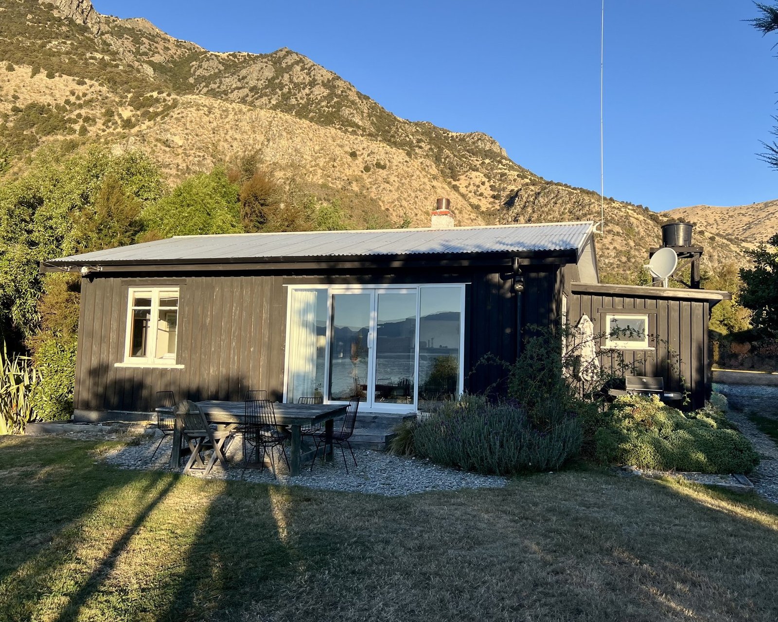 The Black Shack exterior at golden hour, Lake Hawea